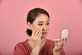 Asian woman looking at her facial problem in the mirror, Female feeling annoy about her reflection appearance show the aging skin.