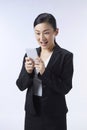 An Asian woman looking at her mobile phone very gladly. Business ideas, job applications, good news, selection, finalists