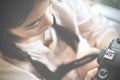 Asian woman looking her photos on her camera, while sitting near window Royalty Free Stock Photo