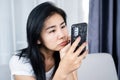 Asian woman looking at mobile phone screen too close to the eye ,social addiction , vision problem concept Royalty Free Stock Photo