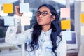 Asian woman looking at sticky notes Royalty Free Stock Photo