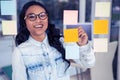 Asian woman looking at sticky notes Royalty Free Stock Photo