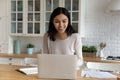 Asian woman looks at laptop smiling read goods news