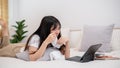 An Asian woman is lying on the bed and crying while watching a drama movie on her digital tablet Royalty Free Stock Photo