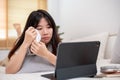 An Asian woman is lying on the bed and crying while watching a drama movie on her digital tablet Royalty Free Stock Photo