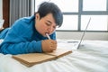 Asian woman lying on bed and writing diary Royalty Free Stock Photo