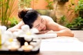 Asian woman lying down on massage bed with scrub sugar and salt aroma at outdoor natural. wellness center, so relax and lifestyle