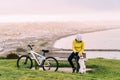 Asian woman making uphill with mountain bike. A woman playing with a dog at lookout point Oamaru, New Zealand Royalty Free Stock Photo