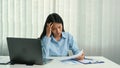 Asian woman manager is stressed and has a headache about faulty work documents at her office Royalty Free Stock Photo