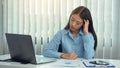 Asian woman manager is stressed and has a headache about faulty work documents at her office Royalty Free Stock Photo