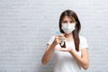 Asian woman in medical protective mask applying an antibacterial antiseptic hand gel for hands Royalty Free Stock Photo