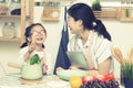 Asian woman mom and daughter play together in kitchen,mom hold tablet for teach little girl how to cook,process in vintage style