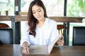 Asian woman open menu for ordering in coffee cafe and restaurant and smiling for happy time Royalty Free Stock Photo