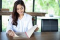 Asian woman open menu for ordering in coffee cafe and restaurant and smiling for happy time Royalty Free Stock Photo