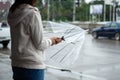 Asian woman opening closing an umbrella while waiting taxi and standing on the city sidewalk street in rainy day Royalty Free Stock Photo