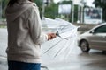 Asian woman opening closing an umbrella while waiting taxi and standing on city sidewalk street in the rainy day Royalty Free Stock Photo