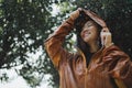 Asian woman is outdoors while it`s raining. She felt refreshed