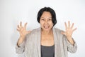 Asian woman over white background crazy and mad shouting and yelling with aggressive expression and arms raised. Royalty Free Stock Photo