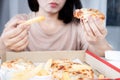 Asian woman overeating pizza and French fries , unhealthy lifestyle , binge eating disorder concept Royalty Free Stock Photo