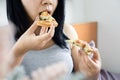 Depressed Asian woman overeating pizza sitting in bed late at night before bedtime  unhealthy eating, lifestyle concept Royalty Free Stock Photo