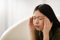 Asian woman in pain touching his head, home interior Royalty Free Stock Photo