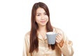 Asian woman in pajamas with toothbrush in mug Royalty Free Stock Photo