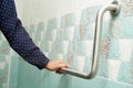 Asian woman patient use toilet support rail in bathroom, handrail safety grab bar, security in nursing hospital