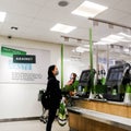 Asian Woman Paying For Shopping In John Lewis Waitrose Using Electronic Check