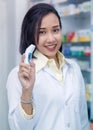 Asian woman pharmacist with digital thermometer standing in pharmacy drugstore Royalty Free Stock Photo