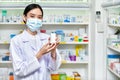 Asian woman pharmacist holding a medicine bottle in pharmacy Royalty Free Stock Photo