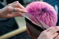 Asian woman with pink hair getting a haircut in a barbershop. Royalty Free Stock Photo