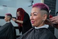 Asian woman with pink hair getting a haircut in a barbershop. Royalty Free Stock Photo