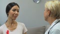 Asian woman with pink ribbon visiting mammologist, breast cancer awareness