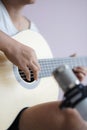 Asian woman play acoustic classic guitar for jazz and easy listening song and record with microphone select focus shallow depth of Royalty Free Stock Photo