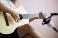 Asian woman play acoustic classic guitar for jazz and easy listening song and record with microphone select focus shallow depth of Royalty Free Stock Photo