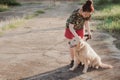 Asian woman playing with her golden retriever dog in a park outdoors Royalty Free Stock Photo