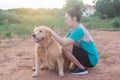 Asian woman playing with her golden retriever dog in a park outdoors Royalty Free Stock Photo