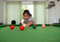 Asian woman playing snooker By aiming at his queue. Focus on the red ball