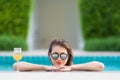 Asian woman in pool with glass of orange juice Royalty Free Stock Photo