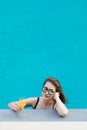 Asian woman in pool with glass of orange juice Royalty Free Stock Photo