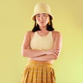 Asian, woman in portrait and fashion with yellow aesthetic, beauty and confident with arms crossed on studio background
