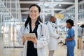 Asian woman, portrait and happy doctor with tablet in hospital for healthcare, telehealth and research. Medical Royalty Free Stock Photo