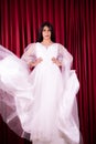 Asian woman poses in a Glamor wedding dress with flying fabric from the dress Royalty Free Stock Photo