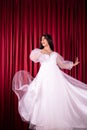 Asian woman poses in a Glamor wedding dress with flying fabric from the dress Royalty Free Stock Photo