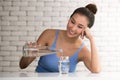 Asian woman pouring water from bottle into glass in the room Royalty Free Stock Photo
