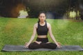 Asian woman practicing yoga in Root Bond, Mula Bandha pose on the mat in outdoor park