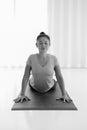 Asian woman practicing yoga , stretching in Cobra exercise, Bhujangasana pose, working out indoor,monochrome Royalty Free Stock Photo