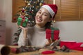 Asian Woman prepare Christmas gift box under X` mas tree in home living room. Royalty Free Stock Photo