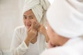 Asian woman pressing acne on her cheek Royalty Free Stock Photo