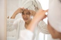 Asian woman pressing acne on her forehead Royalty Free Stock Photo